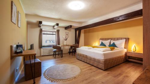 a bedroom with a large bed and a dining room at Allgäu Residenz Natur & Spa GmbH in Wiggensbach