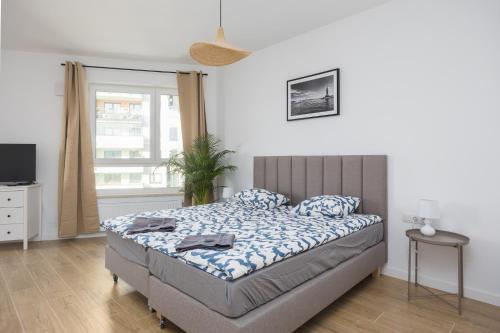 a bedroom with a bed and a tv and a window at Warsaw-Aparts Stegny in Warsaw