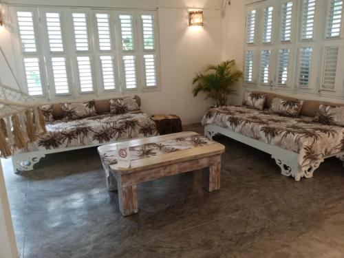 un soggiorno con divani, tavolo e finestre di VILLA MADERA DEL SOL --- Playa Las Ballenas a Las Terrenas