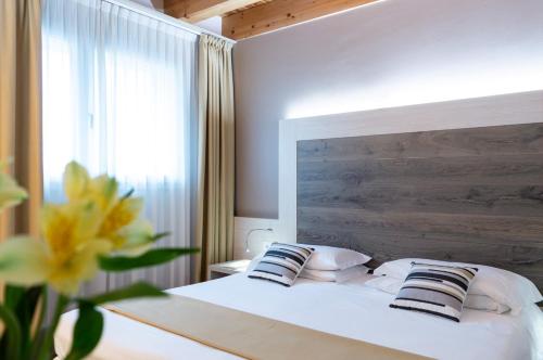 a bedroom with a white bed with pillows and a window at Hotel Alexander in Mestre