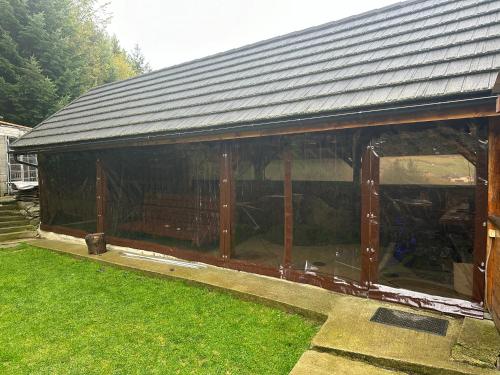 a large greenhouse with a metal roof on the grass at Ubytovanie Privat Antoni - apartmán v RD in Tvrdošín