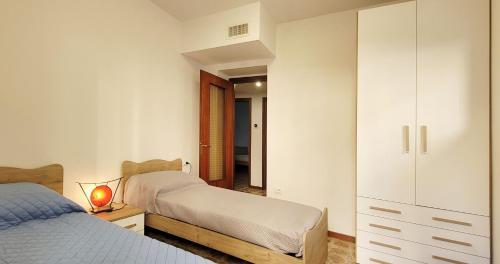 een slaapkamer met 2 bedden en een witte kast bij Il Nido di Moggio - Nibbio Apartment in Moggio
