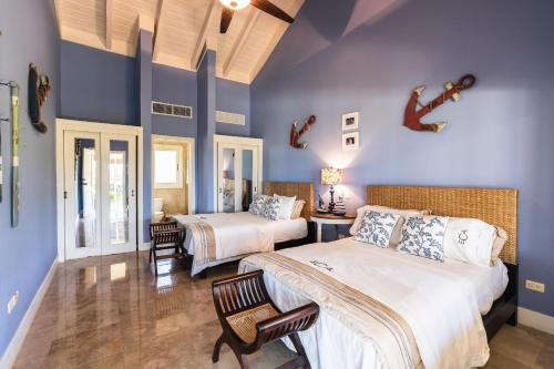 - 2 lits dans une chambre aux murs bleus dans l'établissement Amazing 3 Bedrooms Villa at Puerto Bahia, à Santa Bárbara de Samaná