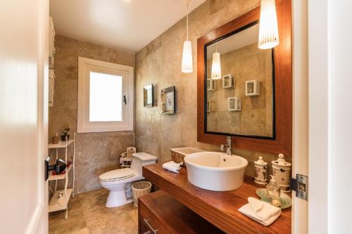 La salle de bains est pourvue d'un lavabo, de toilettes et d'un miroir. dans l'établissement Amazing 3 Bedrooms Villa at Puerto Bahia, à Santa Bárbara de Samaná