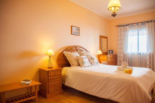 um quarto com uma cama com um urso de peluche em Quinta do Santo by LovelyStay em Santo António da Serra
