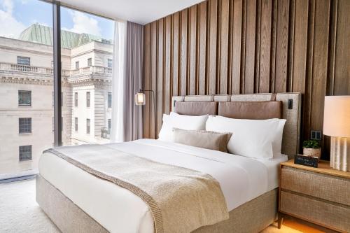 a bedroom with a large bed and a large window at 1 Hotel Mayfair in London