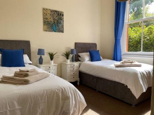 - 2 lits dans une chambre avec des oreillers bleus dans l'établissement Long stays, Special Rates Direct, Free Parking NG7!, à Nottingham