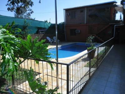 uma cerca em torno de uma piscina num quintal em Residencial Azaleas Place Guest House em Puerto Iguazú