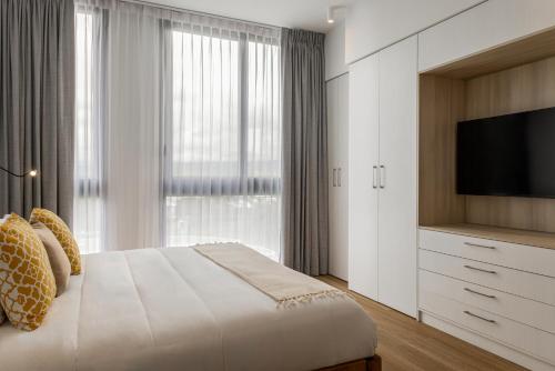 a bedroom with a large bed and a television at Residencias Cityzen cerca del Aeropuerto in Echeverría