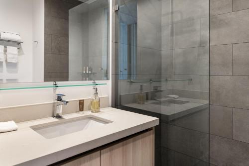 a bathroom with a sink and a glass shower at Residencias Cityzen cerca del Aeropuerto in Echeverría