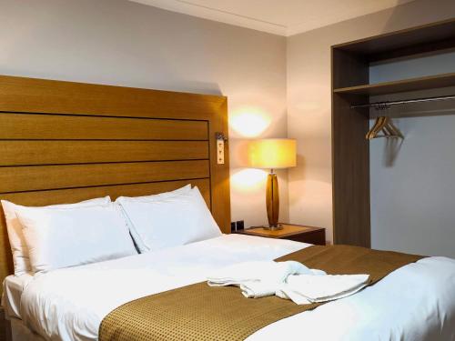 a hotel room with a bed with white sheets at Crown Hotel Stone in Stone