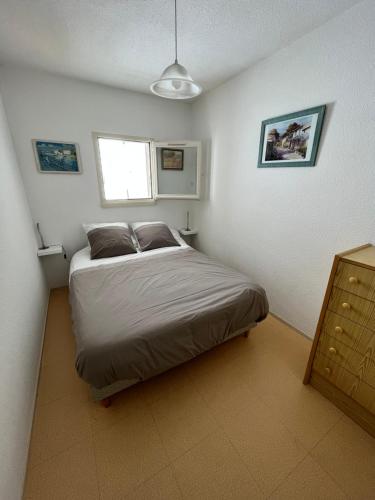 um quarto com uma cama no canto de um quarto em Appartement 1 chambre, avec loggia et vue sur le Port Olona em La Chaume
