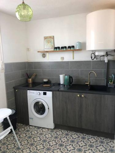 une cuisine avec une machine à laver sur un comptoir dans l'établissement Appartement T3-Montluçon, à Montluçon