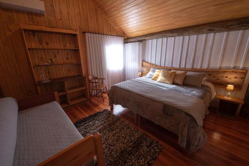 Un dormitorio con una cama en una cabaña de madera. en Monã, en Canela