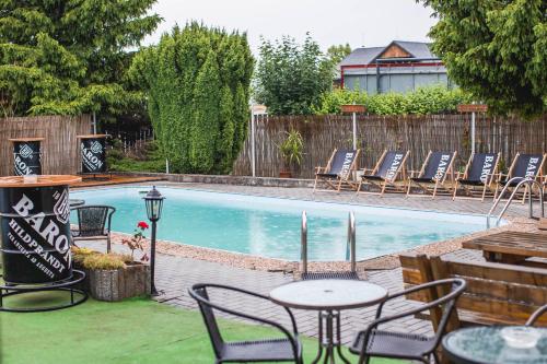 uma piscina com cadeiras e mesas num quintal em Hotel Rozkoš em Česká Skalice