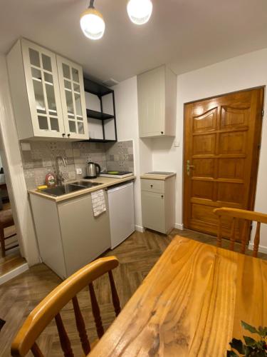 a kitchen with a wooden table and a wooden door at OderPoint#Sauna#Jacuzzi in Gozdowice