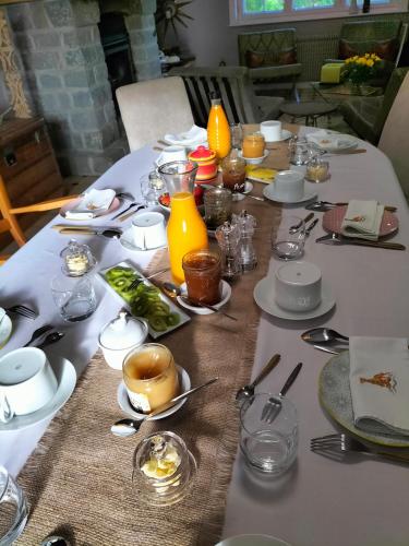 een tafel met een witte tafeldoek met voedsel erop bij La Mouillère in Verton