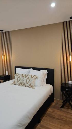 - une chambre avec un lit doté de draps et d'oreillers blancs dans l'établissement Spa des ducs loft 3, à Bar-le-Duc