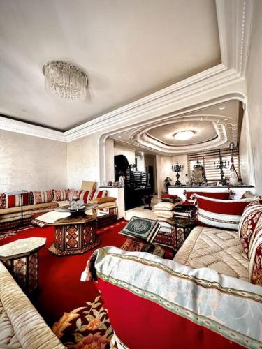 Nassali - Luxurious Beachfront Villa with Private Pool في الدار البيضاء: غرفة معيشة مليئة بالأثاث والسجاد الأحمر