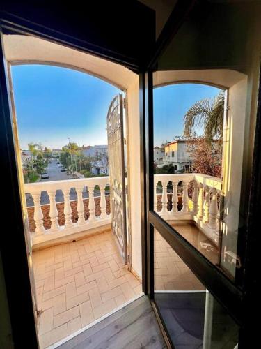 an open door to a balcony with a view of a street at Nassali - Luxurious Beachfront Villa with Private Pool in Casablanca