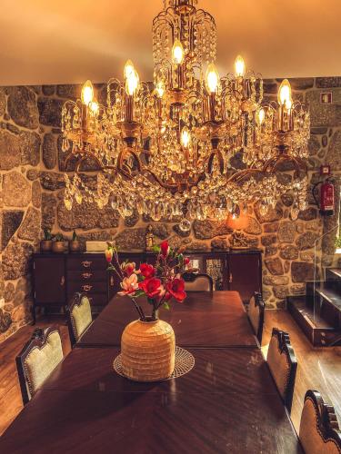 a dining room with a table and a chandelier at Vale da Fonte - Charming Houses in Ponte da Barca