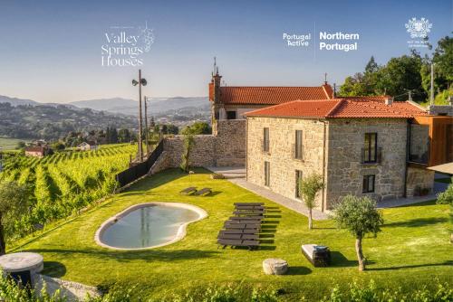 ポンテ・ダ・バルカにあるVale da Fonte - Charming Housesの緑の芝生にスイミングプールがあるヴィラのイメージ