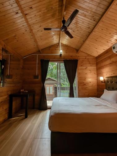a bedroom with a bed and a ceiling fan at Greenland Cottage's Arambol in Arambol