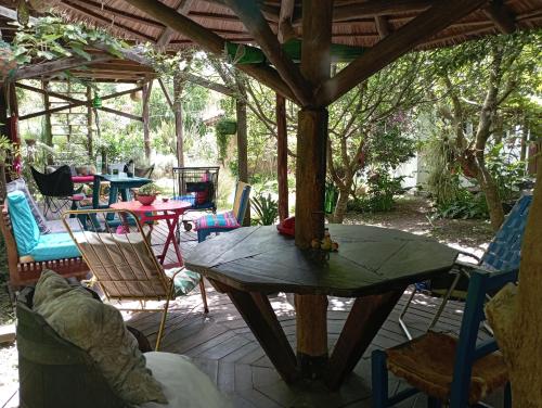 a wooden table and chairs on a patio at Nature Hostel in Barra de Valizas