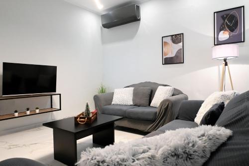 a living room with a couch and a tv at Aura House in Koutsopódhion