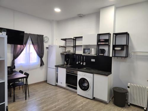 a kitchen with a washing machine and a table at Plan B Madrid Vallecas in Madrid