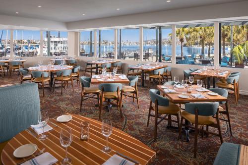 a restaurant with tables and chairs and windows at Bahia Resort Hotel in San Diego