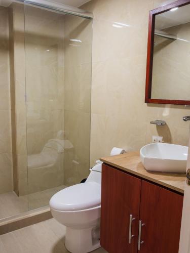 a bathroom with a toilet and a sink and a shower at Grand Hotel Santa Ana in Cuenca
