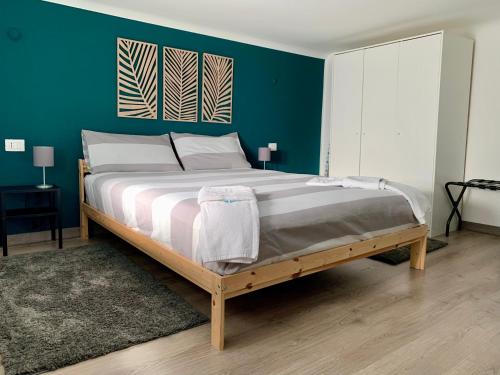 een slaapkamer met een groot bed met een groene muur bij Mini loft a Milano - Città Studi, Porta Venezia in Milaan
