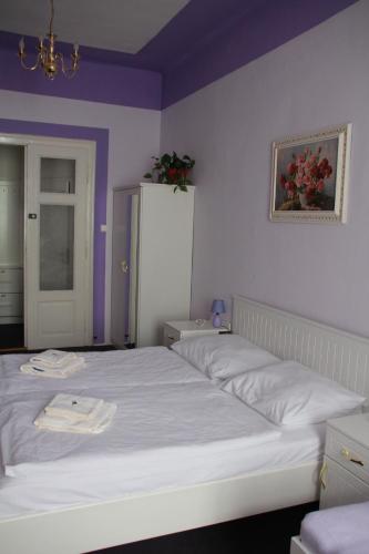 a bedroom with a large white bed with purple walls at Penzion U Lucerny in Jindrichuv Hradec