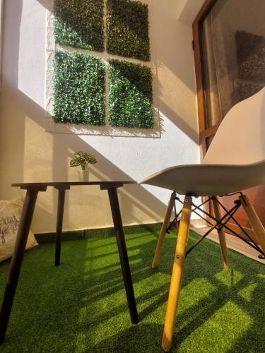 une table et une chaise dans une pièce avec de l'herbe verte dans l'établissement Charite Host Appartement , Wifi et Parking Gratuit, à Agadir