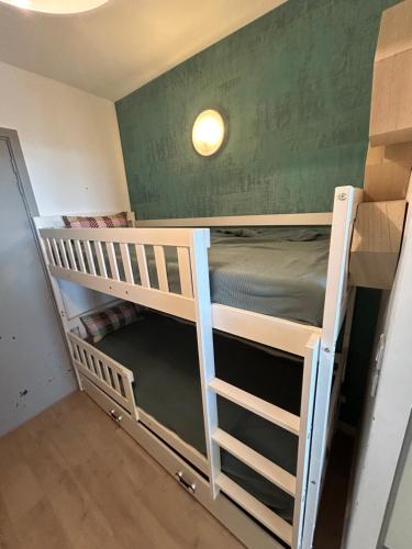 Ce lit se trouve dans un dortoir doté de 2 lits superposés et d'un mur vert. dans l'établissement Studio les nautiles Bandol, à Bandol