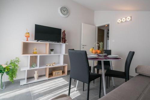 uma sala de estar com uma mesa de jantar com cadeiras em Apartments Sonata em Omiš
