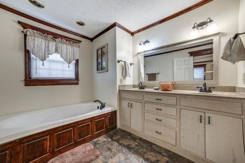 a bathroom with a tub and a sink at Clarksville Home with Porch and Fishing Pond Access! in Clarksville