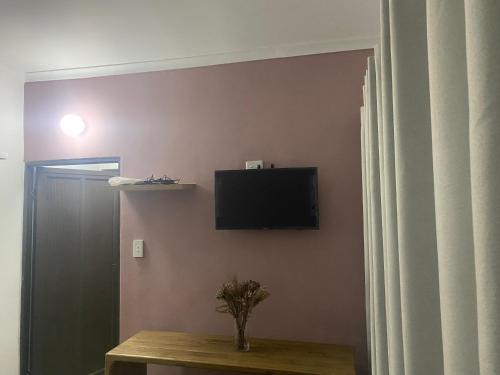 a room with a television on a wall with a table at Studio house in Durban