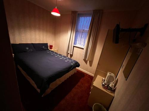 Habitación pequeña con cama y ventana en Lynton Hotel, en Blackpool
