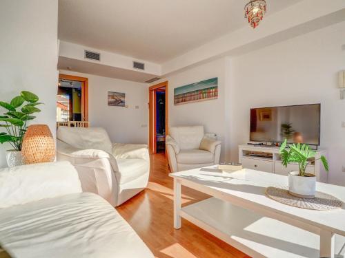 ein Wohnzimmer mit weißen Möbeln und einem Flachbild-TV in der Unterkunft Mimosa Apartment by Hello Homes Sitges in Sitges