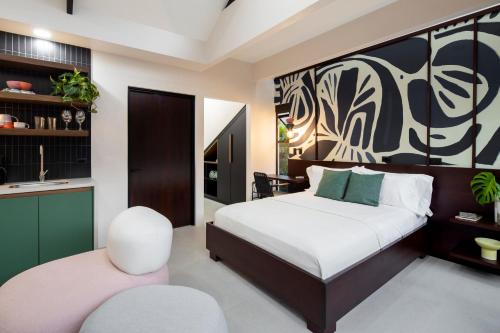um quarto com uma cama grande e uma cadeira em BAUMA em La Fortuna