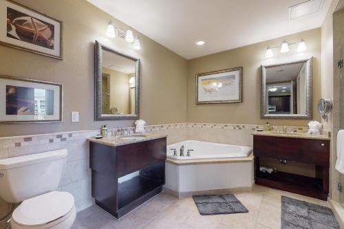 a bathroom with a tub and a toilet and a sink at Sandpearl unit 757 in Clearwater Beach