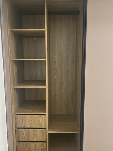 a closet with wooden shelves in a room at Studio house in Durban