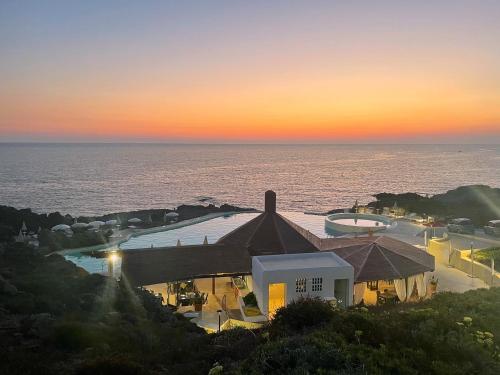 a view of a resort with the ocean in the background at Villa Antioco in Cala Sapone