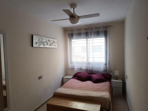 a bedroom with a bed with purple pillows and a window at Apartamento Murcia in Murcia