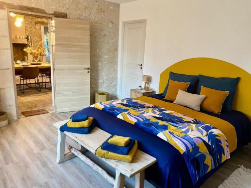 una camera da letto con un grande letto con un piumone blu e giallo di Le moulin du Mesnil a Saint-Georges-sur-Cher