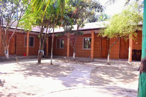 a red brick building with trees in front of it at Jarif st. Martin eco resort in Jaliapāra