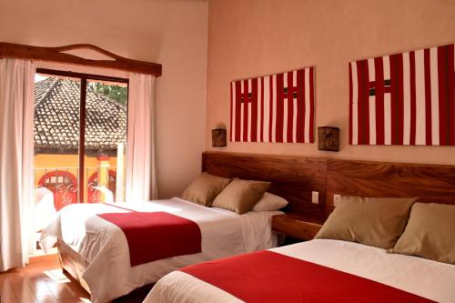 Dos camas en una habitación con banderas americanas en la pared en Hotel Mansion Del Valle, en San Cristóbal de Las Casas