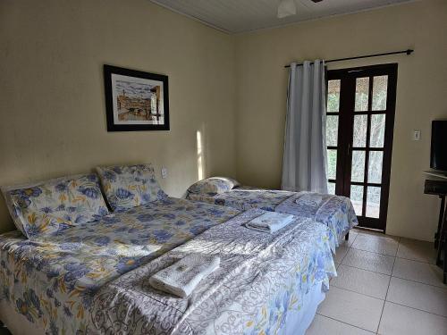 a bedroom with a bed with towels on it at Canto Verde Pousada in Lençóis